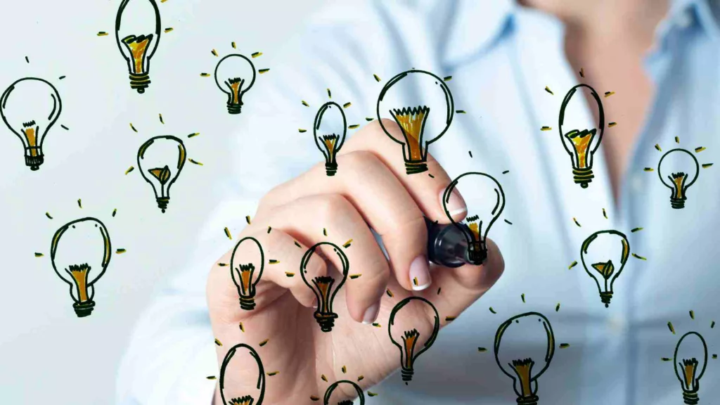 Decorative image. Person drawing light bulbs to represent ideas