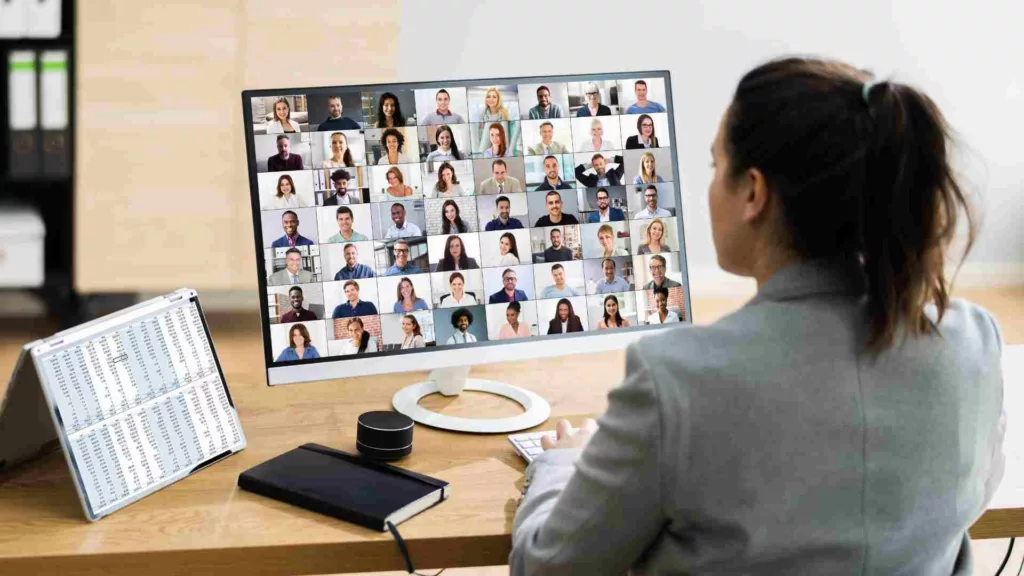 Woman in front of screen in virtual meeting hosting a zoom meeting