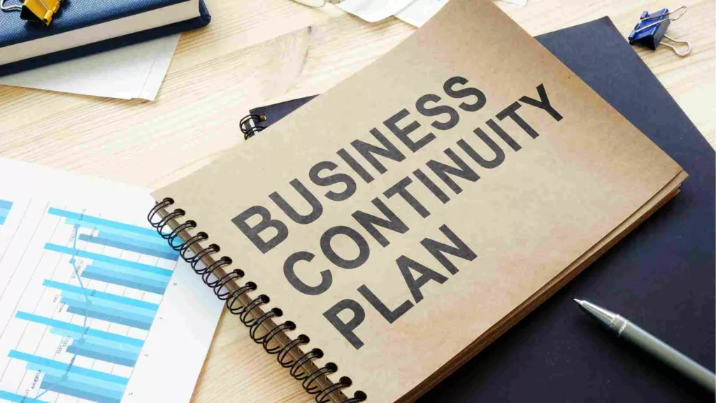 Image of a hard copy business continuity plan on a desk, with print outs of graphs and other papers