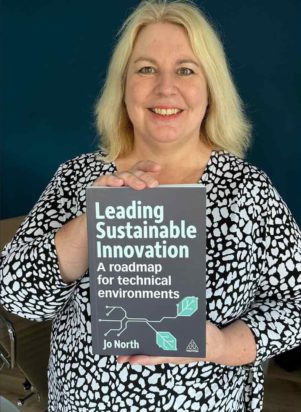 Jo holding her book about leading sustainable innovation