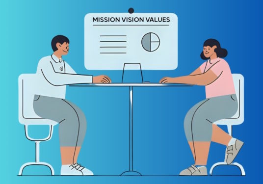 2 people sitting across a table, looking at a chart